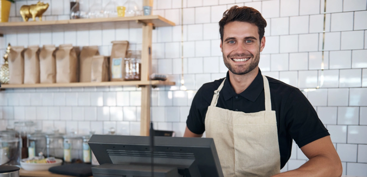 A happy man working on a POS system in a restaurant